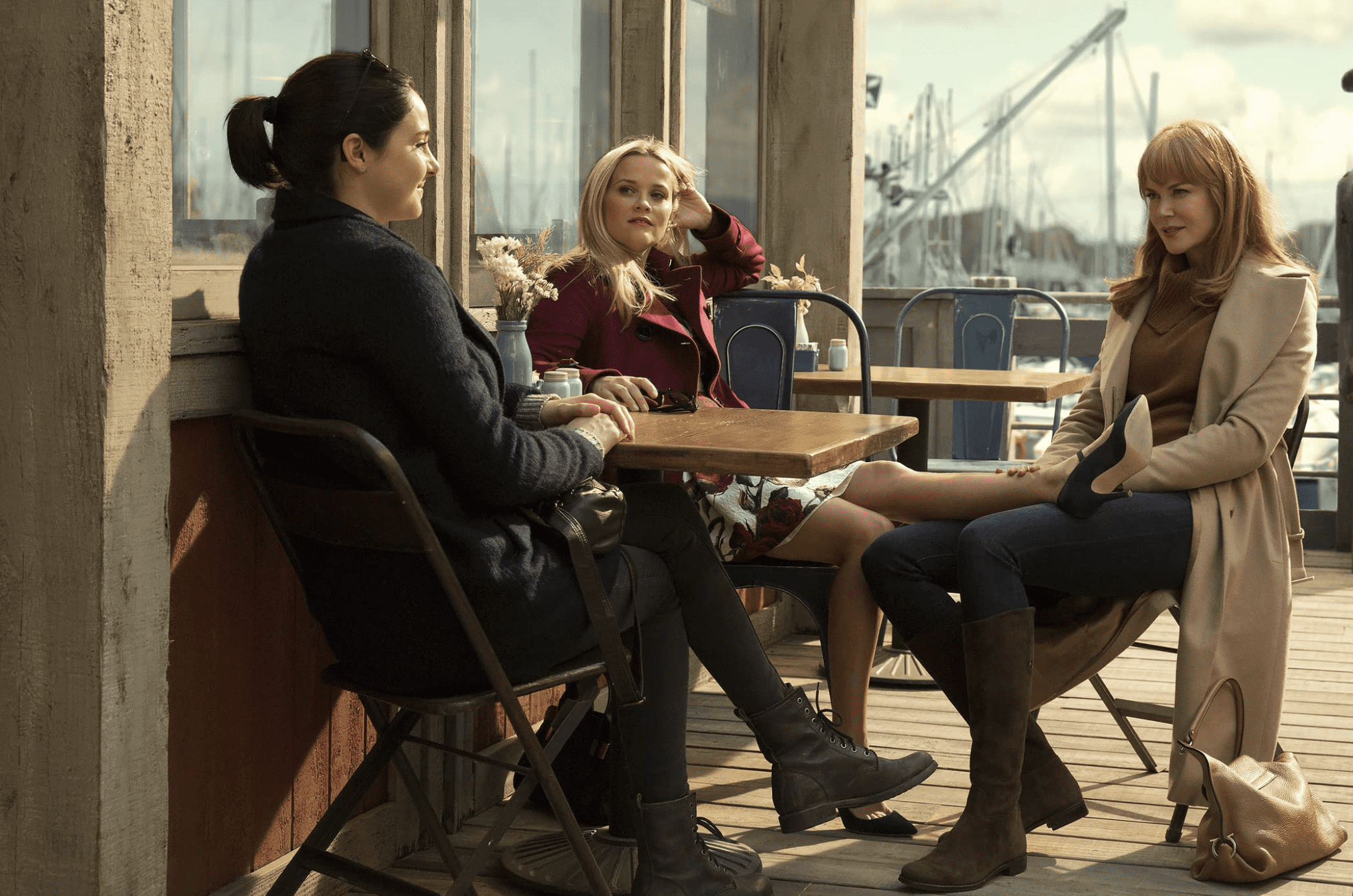 Three friends sit outside a coffee shop in this image from HBO Max